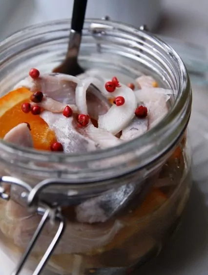 Arenque naranja con pimienta rosa y cebolla blanca